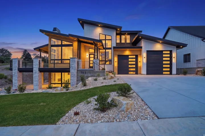 Modern exterior with mixed material facade, large windows, an attached two-car garage, and a concrete driveway