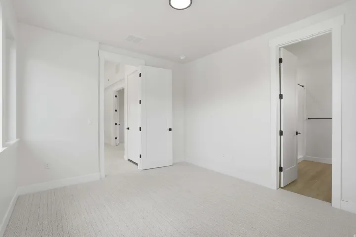 Light-toned carpeted flooring, white walls, recessed ceiling lighting, and white trim