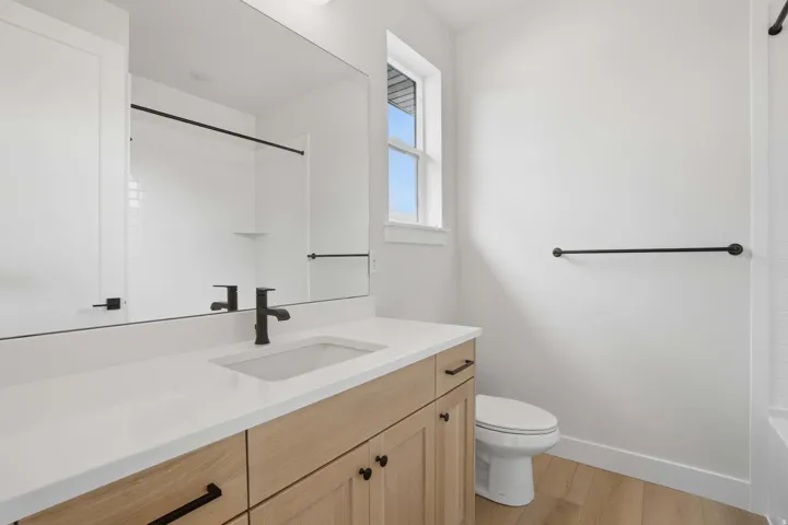 Light wood-finish vanity with an integrated sink and matte black faucet