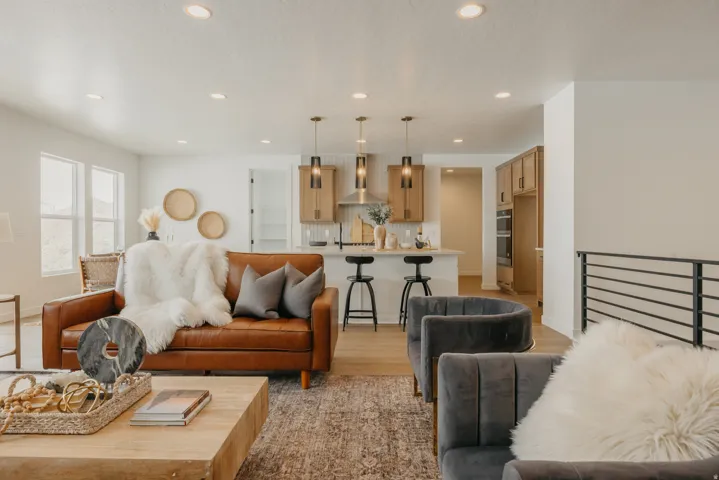 Open-concept living area with recessed lighting, wood-finish flooring, and a contemporary railing
