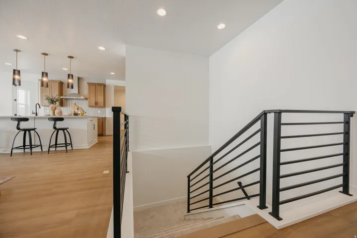 Open-concept kitchen with a large island, wood-finish flooring, and recessed lighting