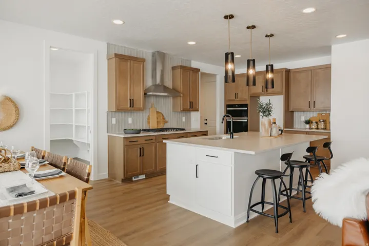 Kitchen featuring a central island with countertop seating, wood-finish flooring, recessed lighting, and a pantry with built-in shelving