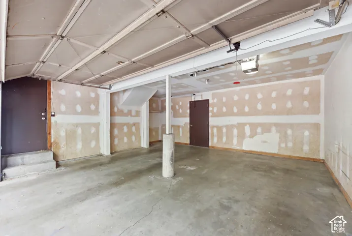 Concrete flooring, exposed ceiling beams, single support column, interior entry door, secondary entry door