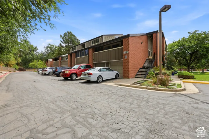 Brick exterior with integrated garage, multiple private entrances, and mature landscaping
