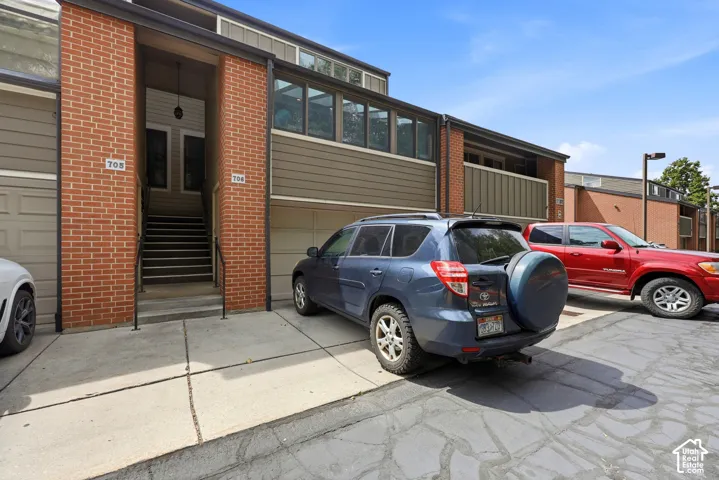 Brick and siding exterior, integrated garage, upper-level windows, and an exterior staircase