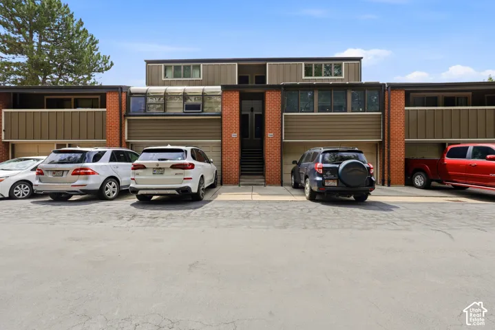 Brick and horizontal siding exterior, multiple garage bays, integrated windows, and a prominent entry staircase