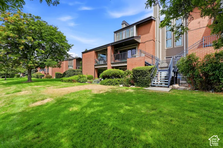 Brick exterior with multiple balconies, wood-look siding, and external staircases