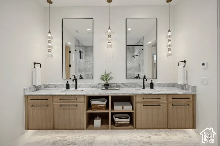 Floating dual vanity with light-toned wood-finish cabinetry, open shelving, and black hardware