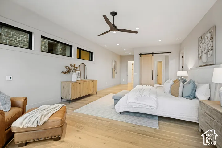 Light wood-finish flooring, recessed lighting, and a ceiling fan with integrated lighting