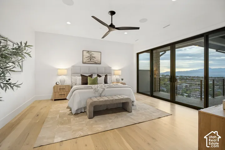 Spacious room featuring wood-finish flooring, a contemporary ceiling fan, recessed lighting, and a full wall of sliding glass doors