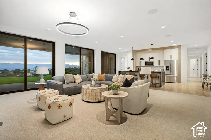 Open-concept living space featuring a modern chandelier, recessed lighting, and large sliding glass doors