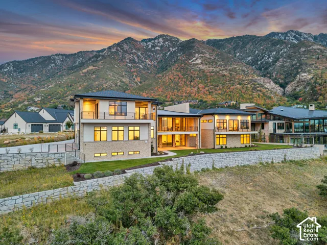 Contemporary architecture with multiple balconies, stone facade, and expansive window arrangement