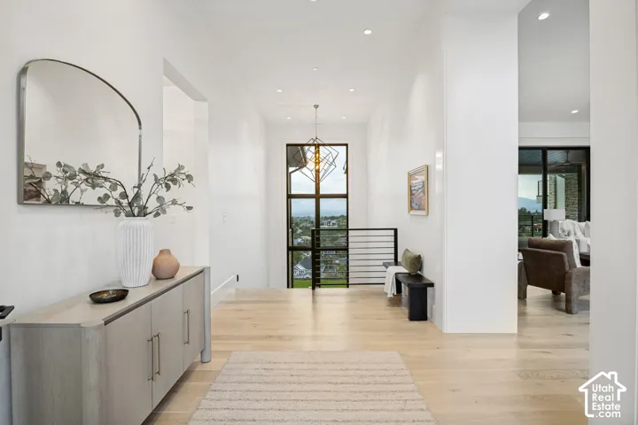 Spacious entry hall featuring light wood-finish flooring, recessed ceiling lighting, and a prominent large window