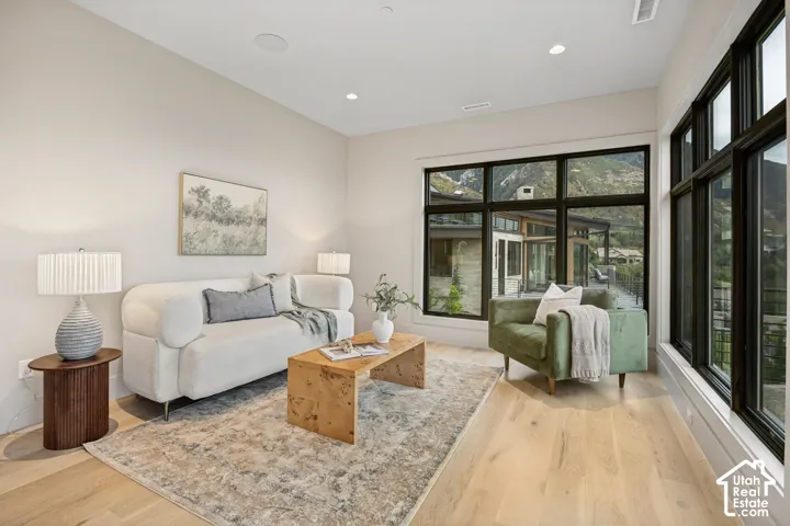 Recessed lighting, wood-finish flooring, large multi-pane windows, and a panoramic mountain backdrop