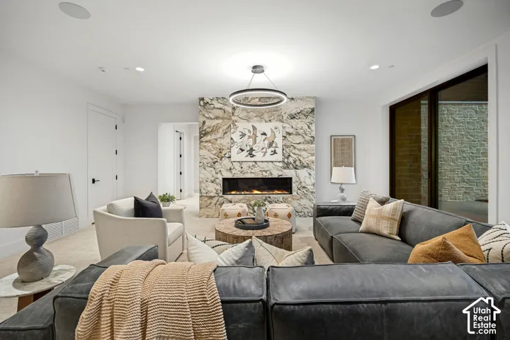 Recessed lighting, large format stone fireplace surround, electric fireplace insert, and built-in ceiling speakers