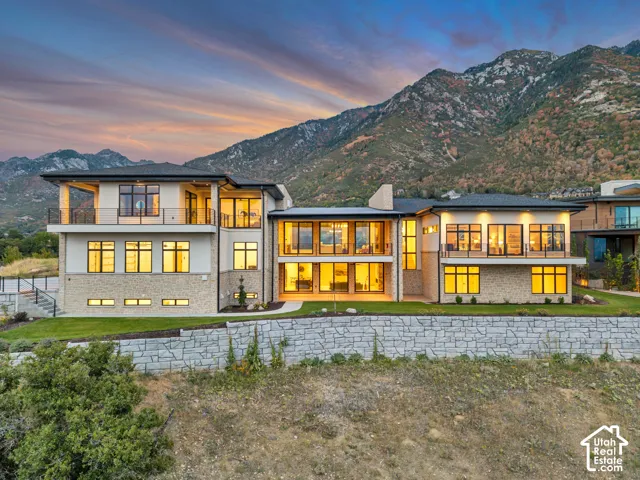 Modern exterior with extensive glazing, stone and stucco facade, and multiple private balconies