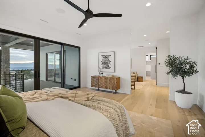 Spacious room with light wood-finish flooring, a contemporary black ceiling fan, and recessed lighting