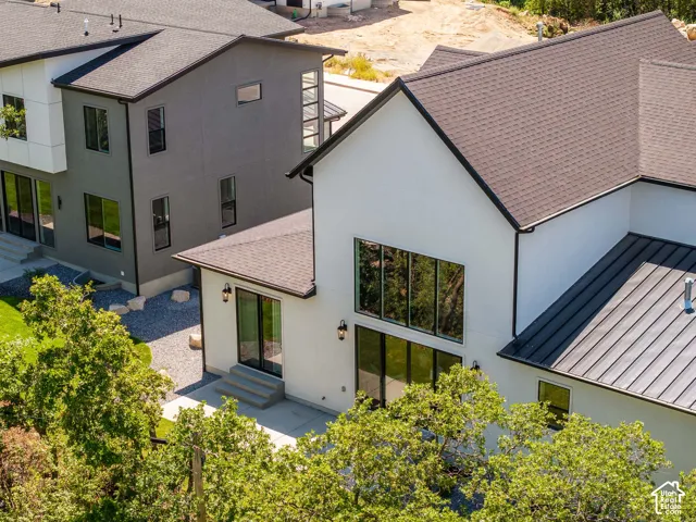 Contemporary exterior with a white and black facade, large windows, and a combination of shingle and standing seam roofing