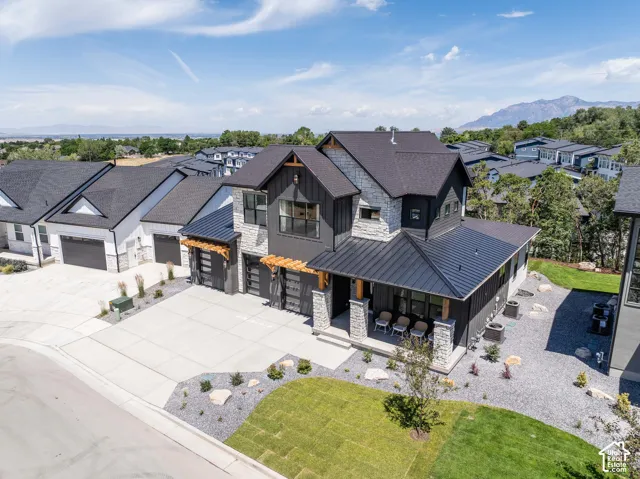 Modern exterior featuring a dark vertical siding, stone accents, and a multi-level roofline
