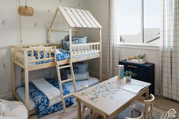 Room featuring a bunk bed with a house-frame top, a window, and a dark blue dresser