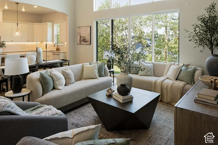 Open-concept living area featuring a vaulted ceiling, full-height windows, recessed lighting, and wood-finish flooring