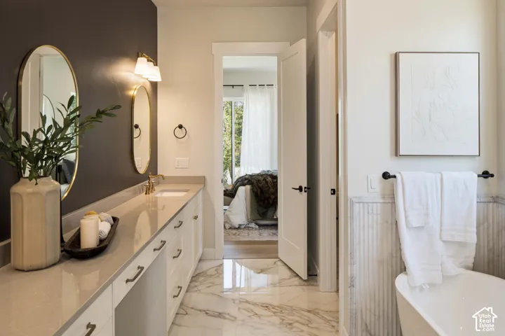 Dual vanity with integrated sinks, light-toned countertop, and gold-finish hardware