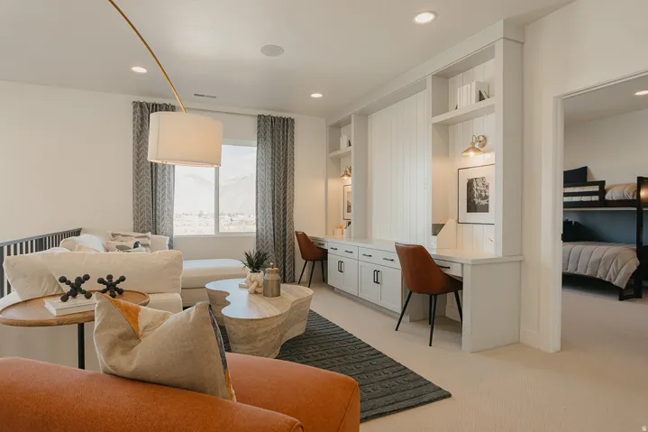Open-concept space featuring two built-in desk areas, recessed lighting, and a window with distant mountain scenery