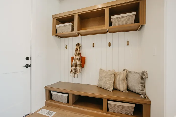 Built-in wood-finish bench with integrated storage cubbies