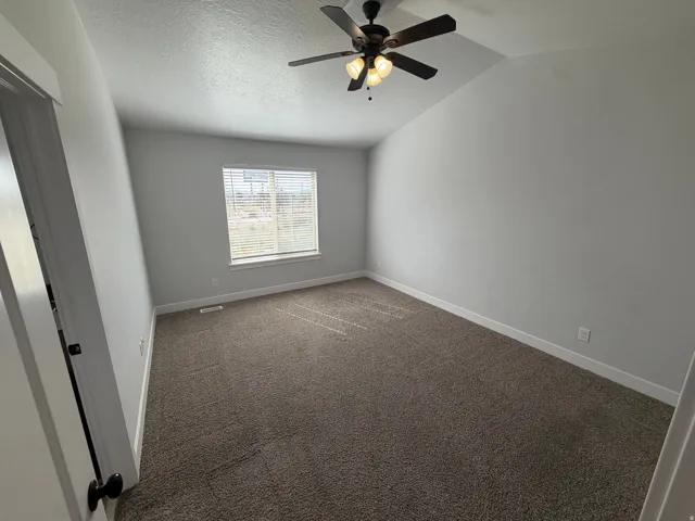 Vaulted ceiling with an attached ceiling fan and light fixture
