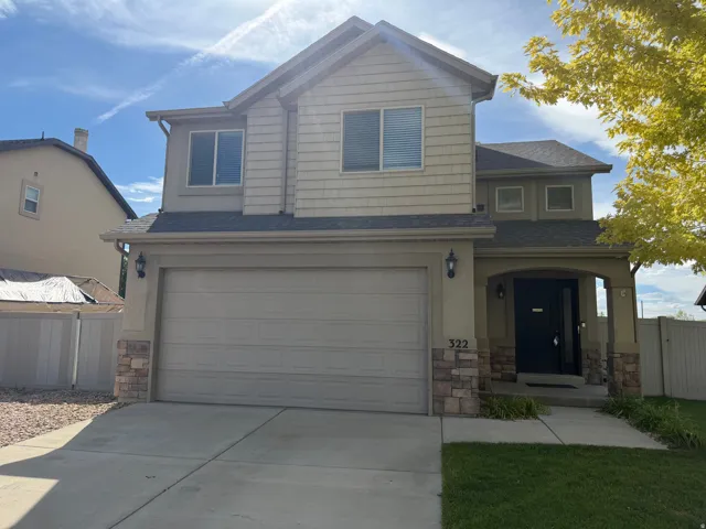 Two-story residence featuring a two-car garage, stone veneer accents, and a covered entryway