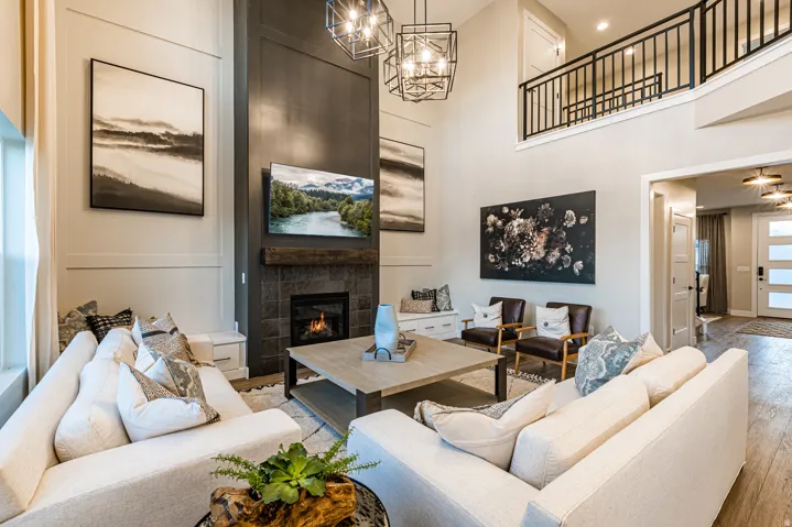 Two-story living area with a dark tile fireplace and wood mantel
