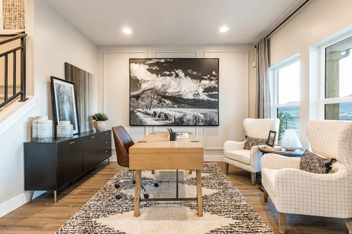 Wood-finish flooring, recessed lighting, accent wall paneling, and a black metal stair railing