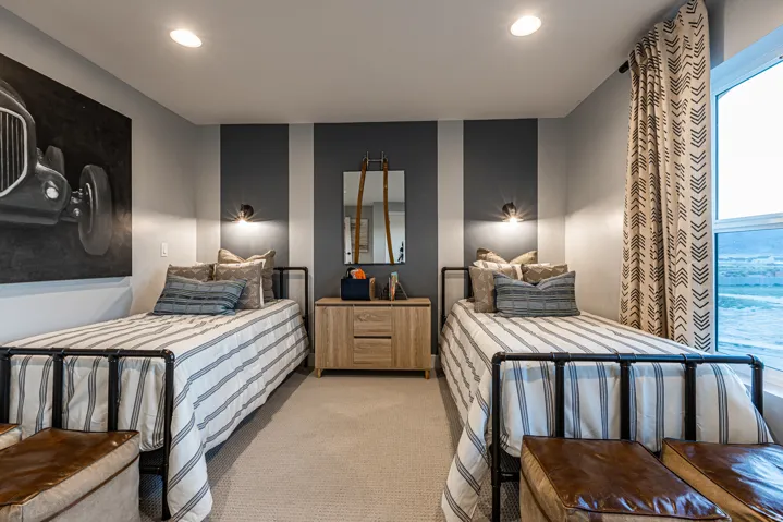 Recessed lighting, wall sconces, striped accent wall, light wood-finish dresser, and a large window