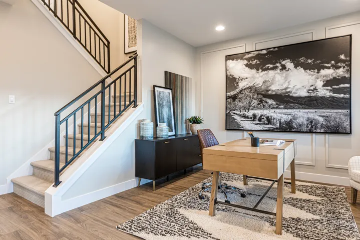 Wood-finish flooring throughout, complemented by a prominent staircase featuring black metal railings