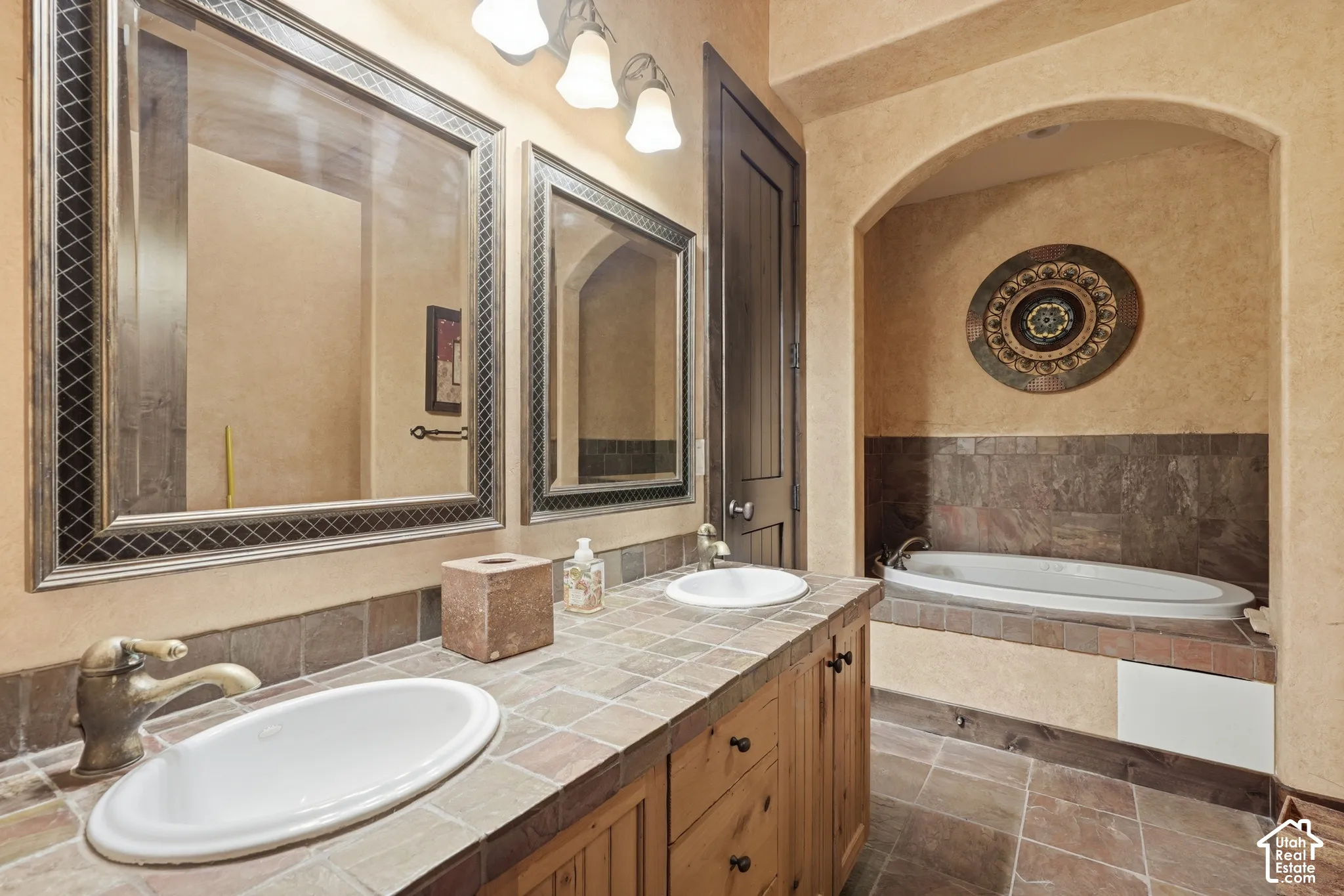 Dual vanity with tile countertop, individual mirrors, and wood-finish cabinetry