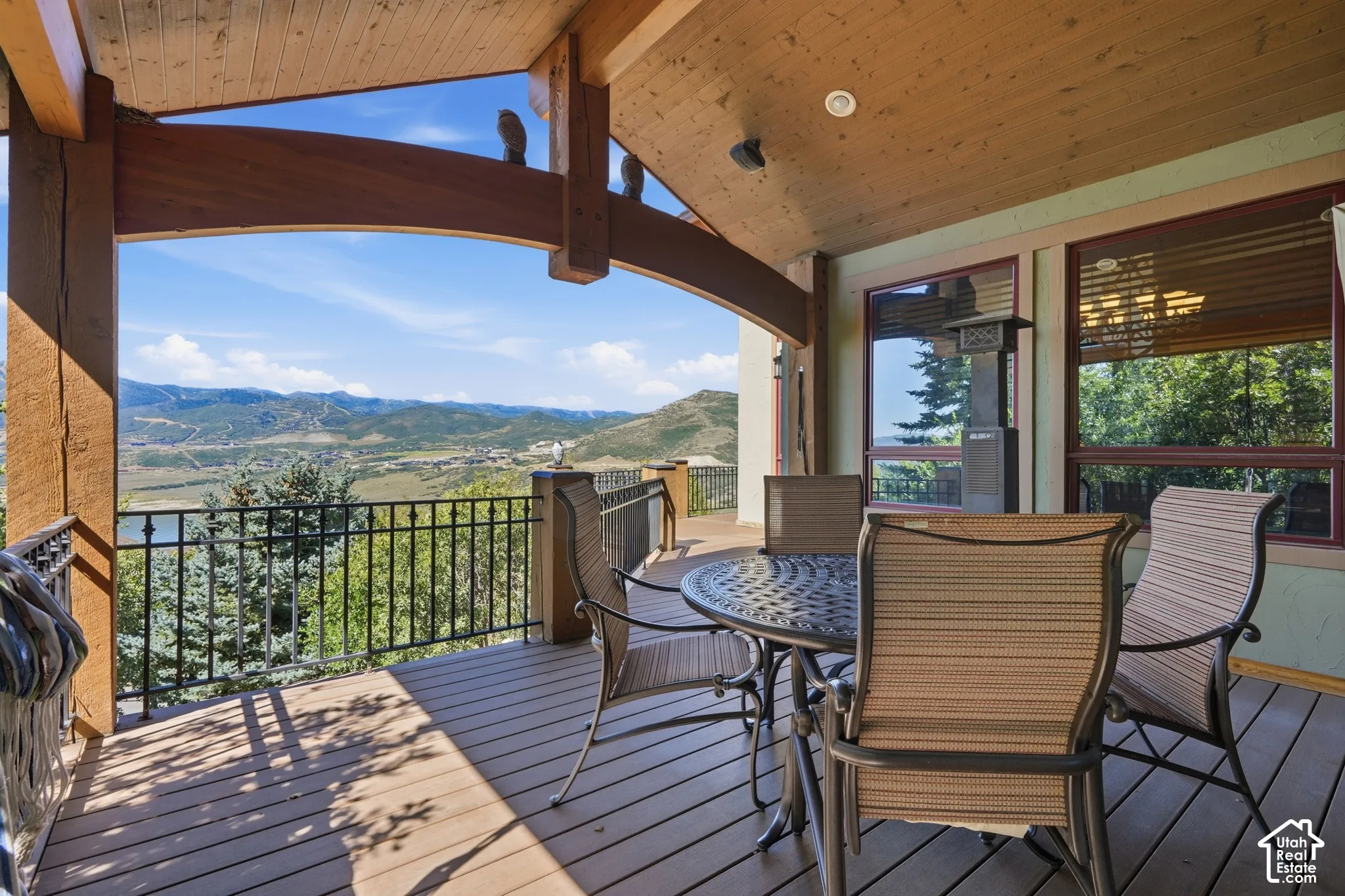 Expansive outdoor deck featuring wood-finish flooring and a black wrought iron railing