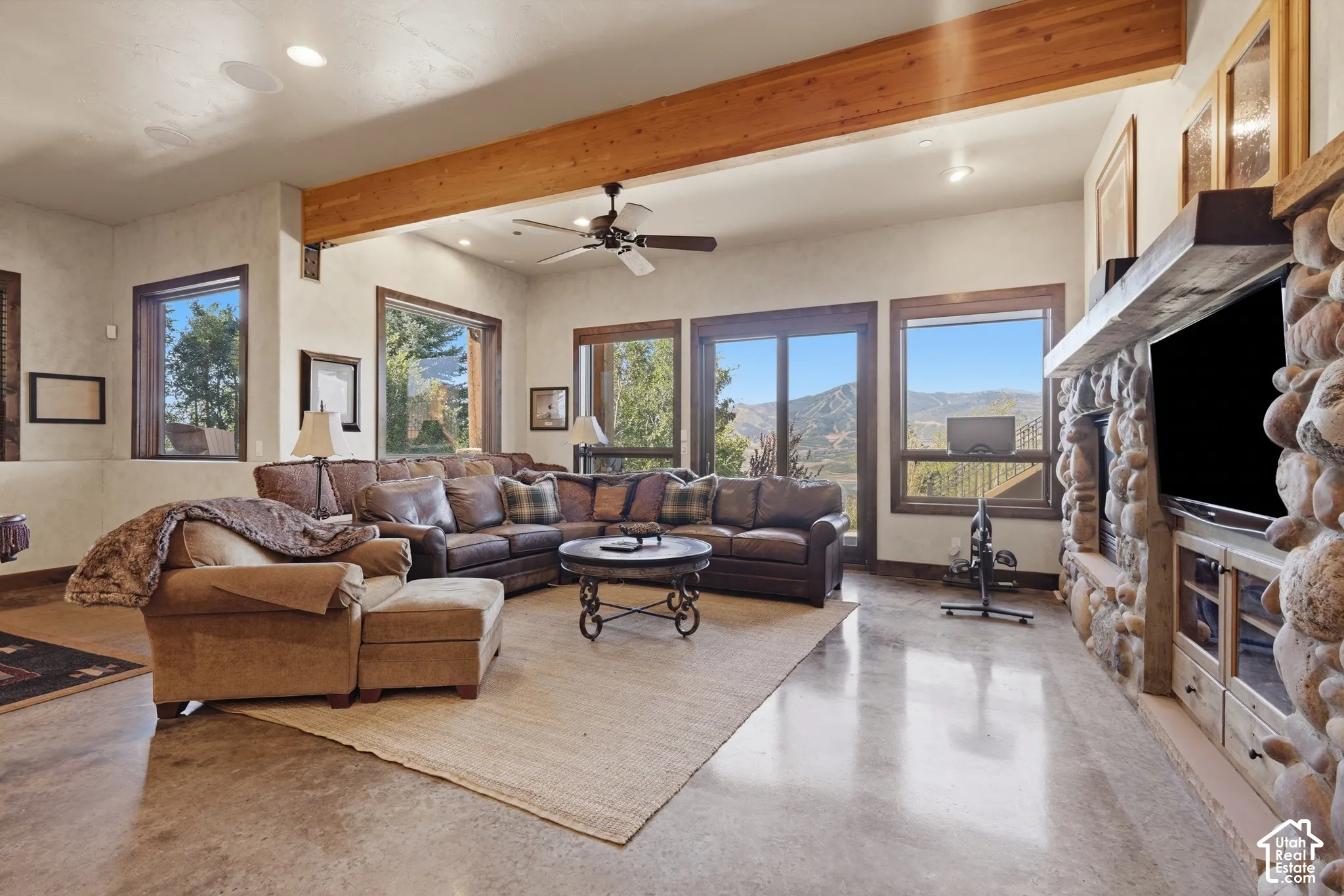 Exposed wood beam, recessed lighting, and ceiling fan
