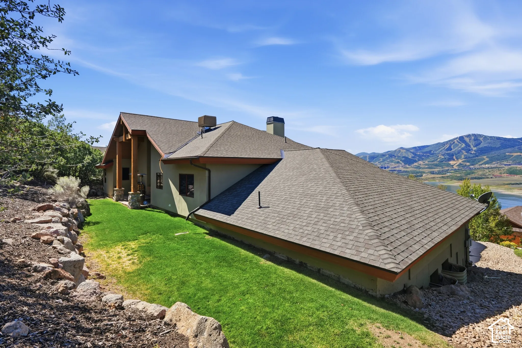 Split-level residence featuring a multi-pitch asphalt shingle roof and stucco siding