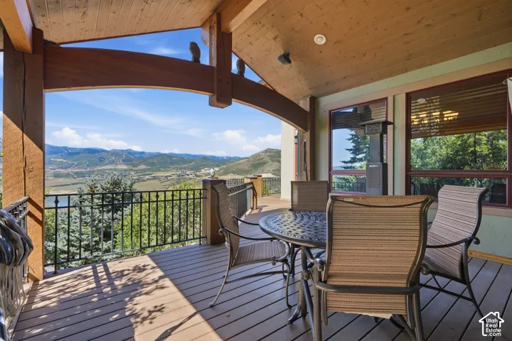 Expansive outdoor deck featuring wood-finish flooring and a black wrought iron railing