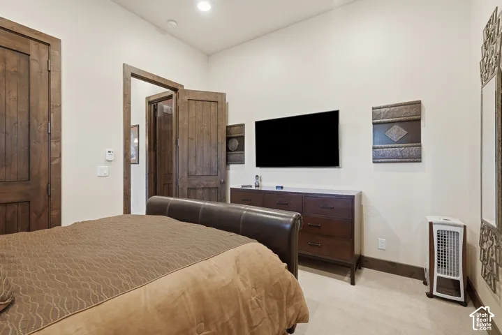 High ceilings with recessed lighting, wood-finish doors, carpet flooring, and a built-in wall niche
