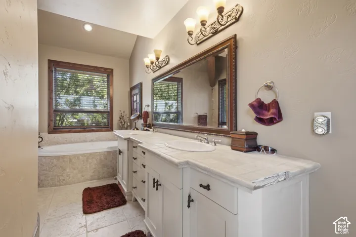 Dual vanity with integrated sinks, framed mirrors, and wall-mounted light fixtures