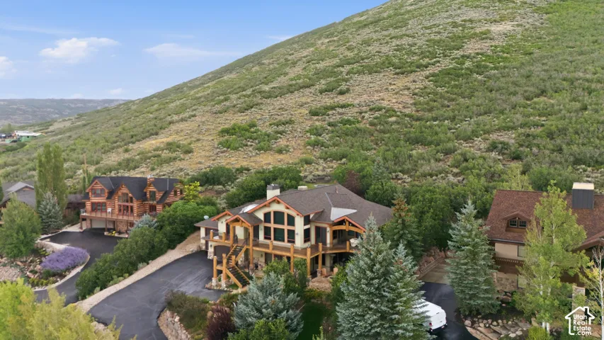 Multi-level property featuring extensive decking, prominent windows, and a multi-car driveway