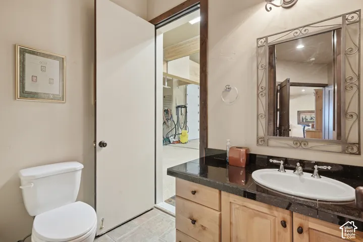 Wood-finish vanity with a dark countertop and integrated white sink