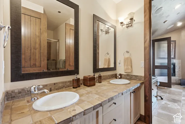 Dual vanity with integrated sinks, tiled countertop, and matching tiled backsplash