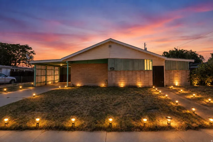 Single-story residence featuring a carport, brick lower exterior, and a gabled roofline
