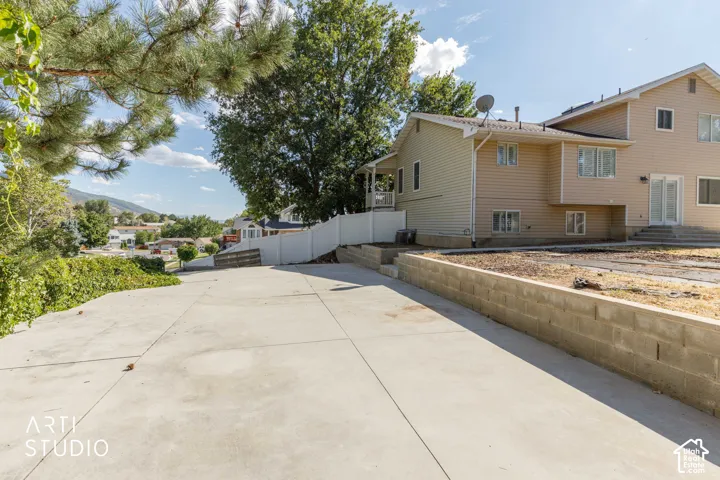 Concrete driveway with a retaining wall, offering access to the property
