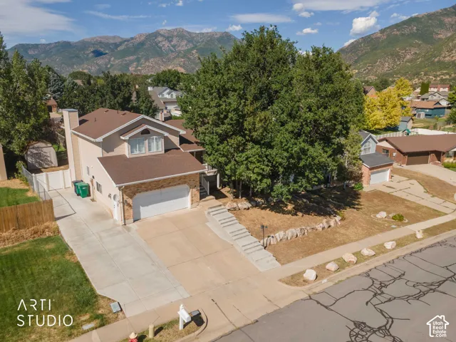 Two-story residence with a two-car garage, an additional single-car garage, and a concrete driveway