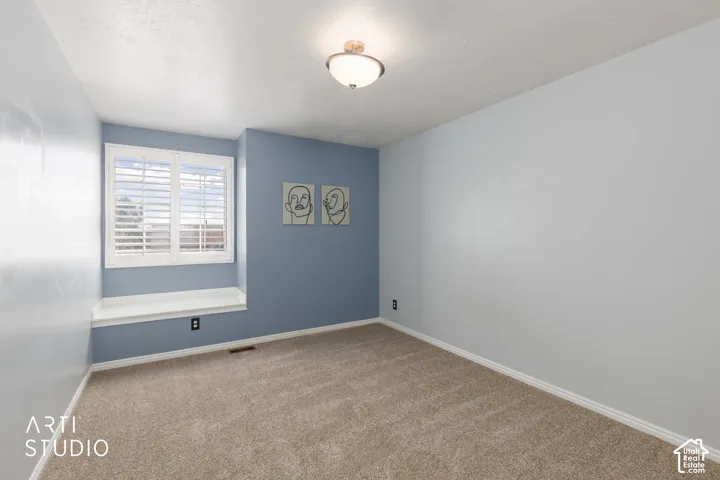 Wall-to-wall carpeting, window with plantation shutters, integrated window bench, and a flush-mount ceiling light fixture
