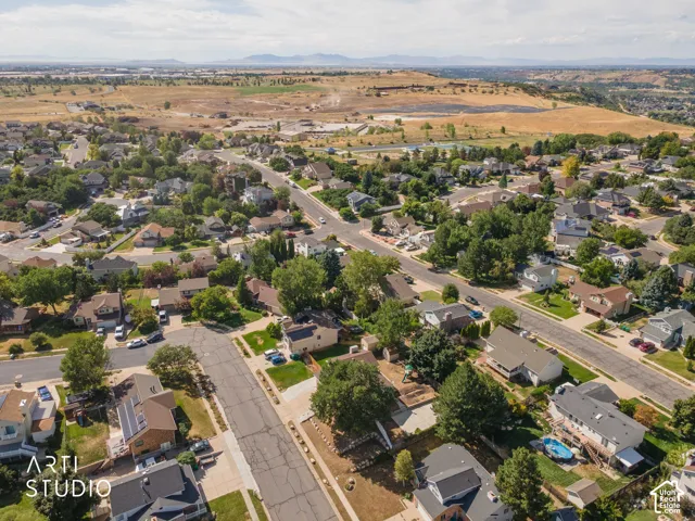 Residential neighborhood with mature trees, established streets, distant mountains, and open terrain