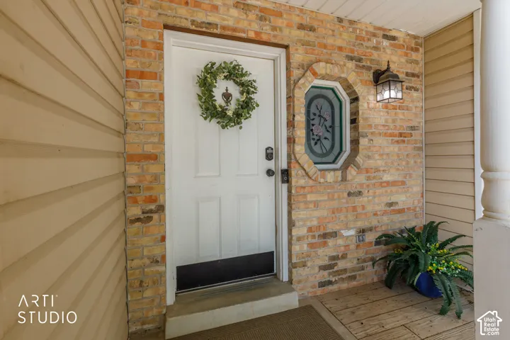 Brick and siding exterior featuring a white entry door, decorative stained-glass window, and an exterior wall lantern